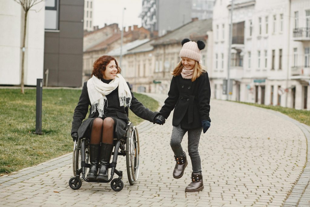 A person in a wheelchair holding hands with another person
