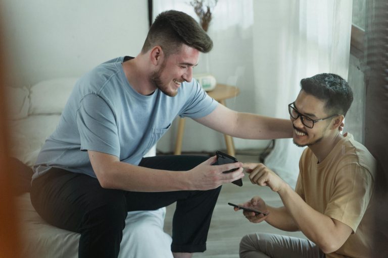 Men Smiling while Looking at the Cellphone