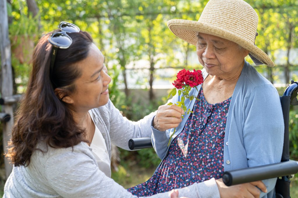 A client is receiving a flower from one of her caregivers